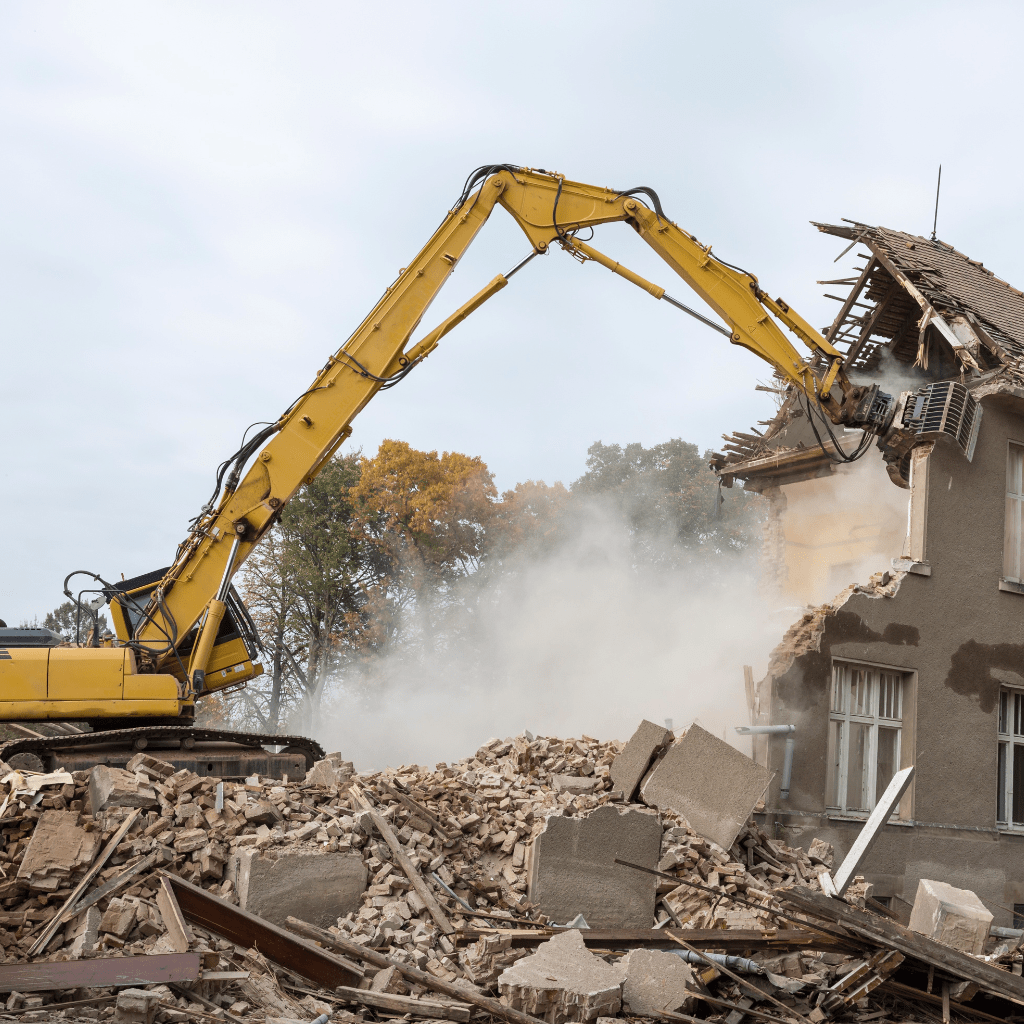 Excavator Pulling a wall apart, Building Debris all over