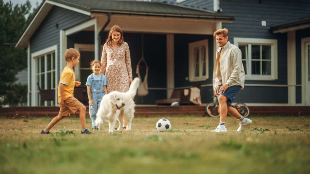 Family playing in back yard with dog